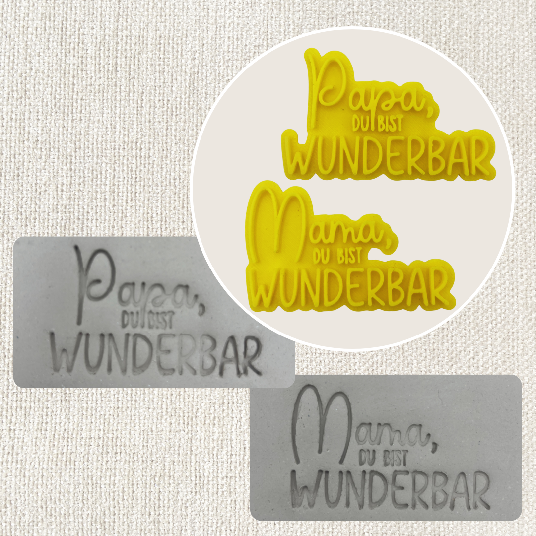 Stempel mit den Worten "Mama du bist die wunderbar" und "Papa du bist wunderbar" von ARTHummeln, mit bunten Schriftzügen.