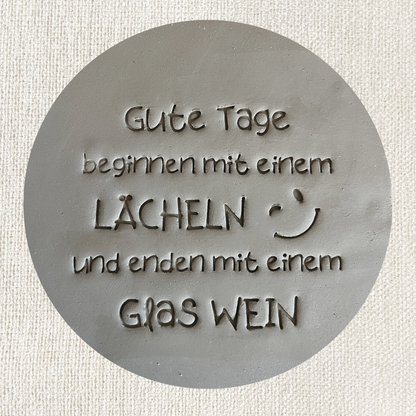 Tonstempel mit dem Spruch "Gute Tage beginnen mit einem Lächeln und enden mit einem Glas Wein" für Töpferwaren, detailreiche Gestaltung