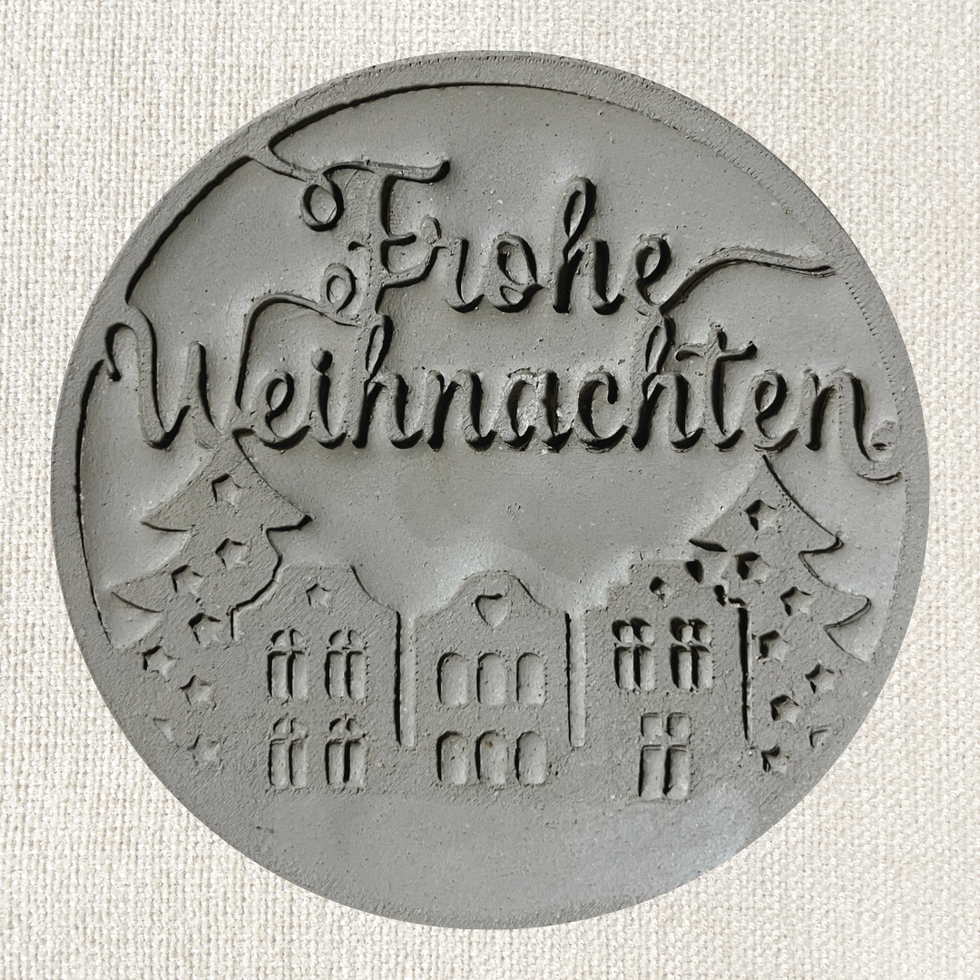 Runder Frohe Weihnachten Stempel aus Ton für Töpferwaren, mit weihnachtlichem Design und klarer Schrift.